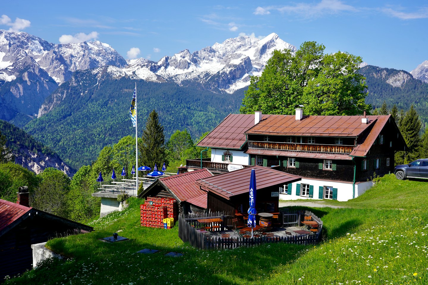 Traditionelle bayerische Gebäude stehen auf einem üppig grünen Hügel.